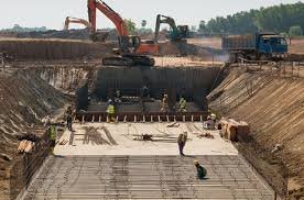 Excavator grading site for foundation preparation